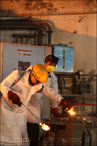 Workers with molten metal equipment