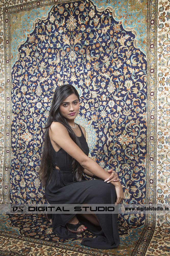 Model posing next to oriental carpet