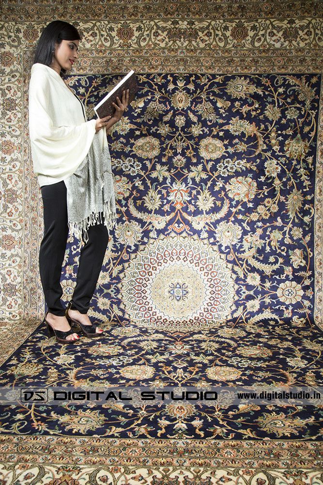 model reading a book on Kashmir carpet