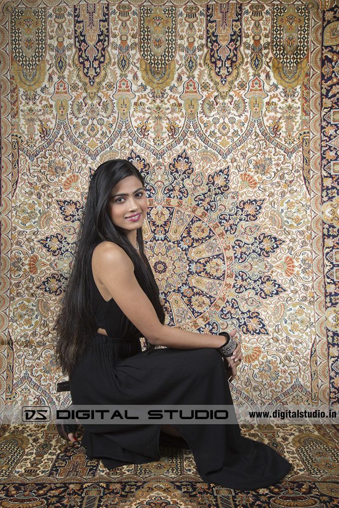 Model sitting in front of oriental rug